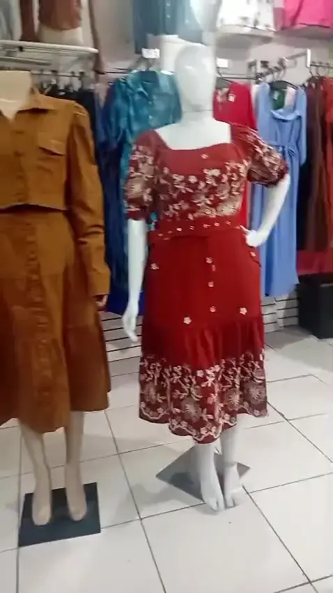 Vestido vermelho florido e conjunto caramelo nos manequins